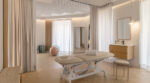 Treatment room at EstudioFisio Goya physiotherapy clinic showing an adjustable treatment table, a woven bench, a fluted oak vanity with sink and mirror, ceiling track curtains dividing the treatment and Pilates areas, and herringbone wood flooring.